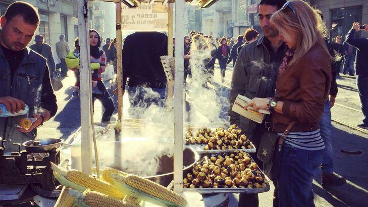 Couple buying grilled corn on the cob on famous Istiklal Avenue, Istanbul.