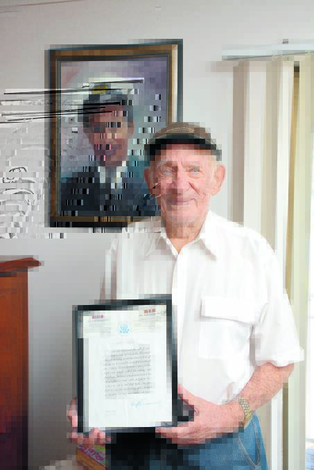 Charles Clifton with two of his prized possessions: a citation from former US president Harry Truman thanking him for his service in the war, and a portrait of himself during service, painted by his  
daughter Sandra Moore.