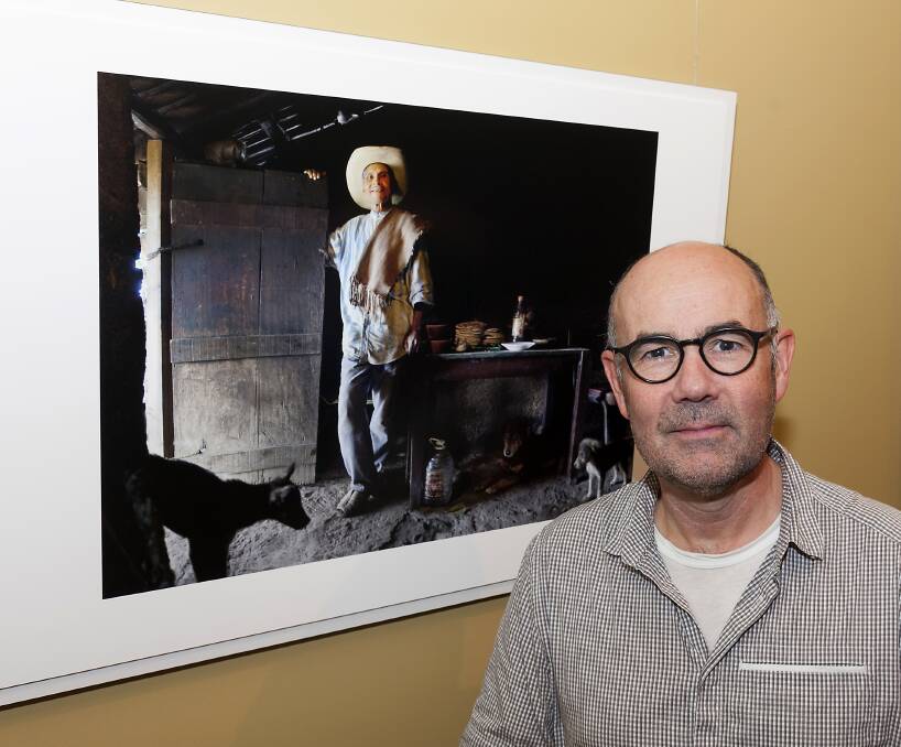 Melbourne photographer Stuart Crossett with Mike's work 'Portrait of Domingo, a farmer in his home with his dogs' - Mexico 2005. Ashley Cleaver photo.