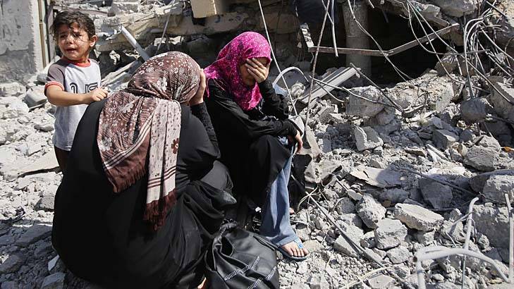 Palestinian women sit on the rubble of their home in Beit Hanoun. Photo: Hatem Moussa
