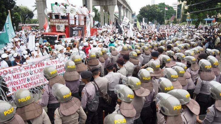 Supporters of the FPI face off with some of  the 2800 police who were brought in outside Indonesian police HQ in Jakarta. Photo: Dewi Nurcahyani