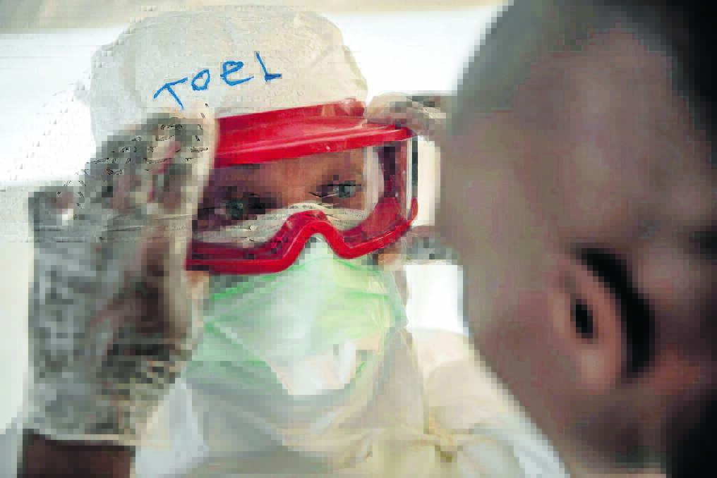 Joel Donkin puts on PPE. Pic: Tommy Trenchard/Australian Red Cross.