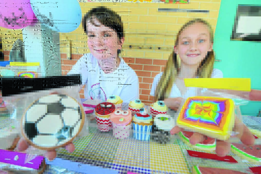Hallidays Point Public School students Jacob Cain and Halle Ford display the cakes at their cancer fundraiser stall.