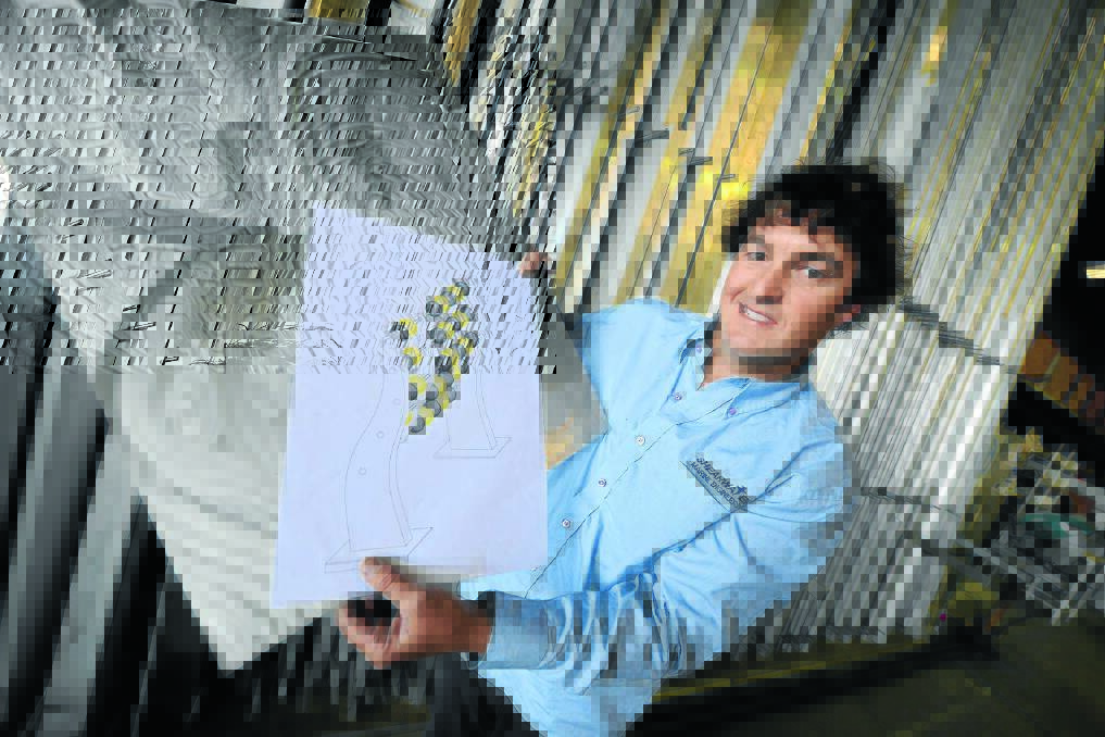 Lee Black with his design for the interactive sculpture destined for Victoria Street, Taree. The stainless steel sculpture is reminiscent of an abacus but incorporates local thematic elements.