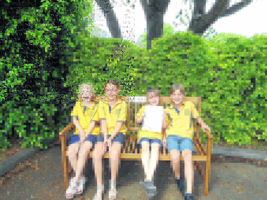 Ruby Stewart, Harry Waite, India Robertson and Nicholas Harper try out the buddy bench.