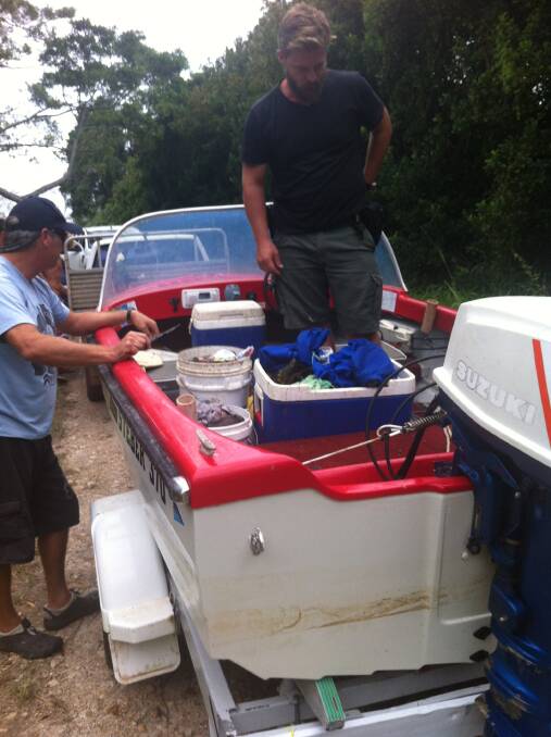 Seized: Fisheries officers in the boat of a man who was allegedly caught with eight times the daily bag and  
possession limit of mud crabs in Hastings River.