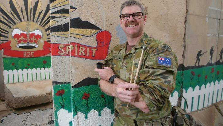 Major Adrian Sweatman, of Brisbane, has continued working on  the Anzac mural that was started by the first contingent at Camp Sosi, in Iraq. Photo: Gary Ramage