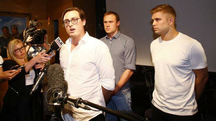 Nick Kelly, one of the nine Australians who stripped at the Formula One in Malaysia last weekend delivers a statement at Sydney International Airport on Friday. Behind him are Thomas Laslett and Edward Leaney, right. Photo: Daniel Munoz