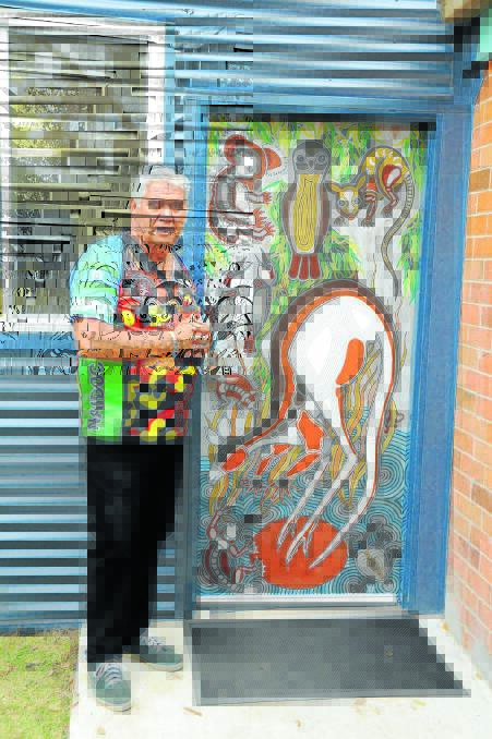 Russell Saunders with the door he painted for the entry into 'Ngarralbaa'.