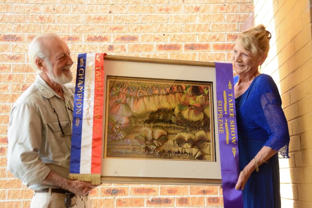 A champion collaboration: Dr Jim Frazier's OAM ACS and Lynne Jones hold the pale tole artwork "Dancing for the Earth". For 12 months Lynne worked to recreate Jim's artwork "Another Place, Another Time" using the art of paper tole. She entered it in Taree Show where it came away with an array of awards.
