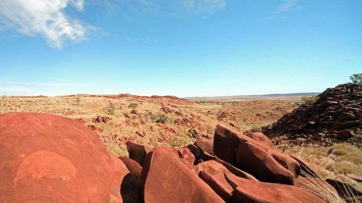 The country of the Burrup Peninsula, with petroglyph, or rock art, in the foreground. Photo: Murujuga Aboriginal Corporation