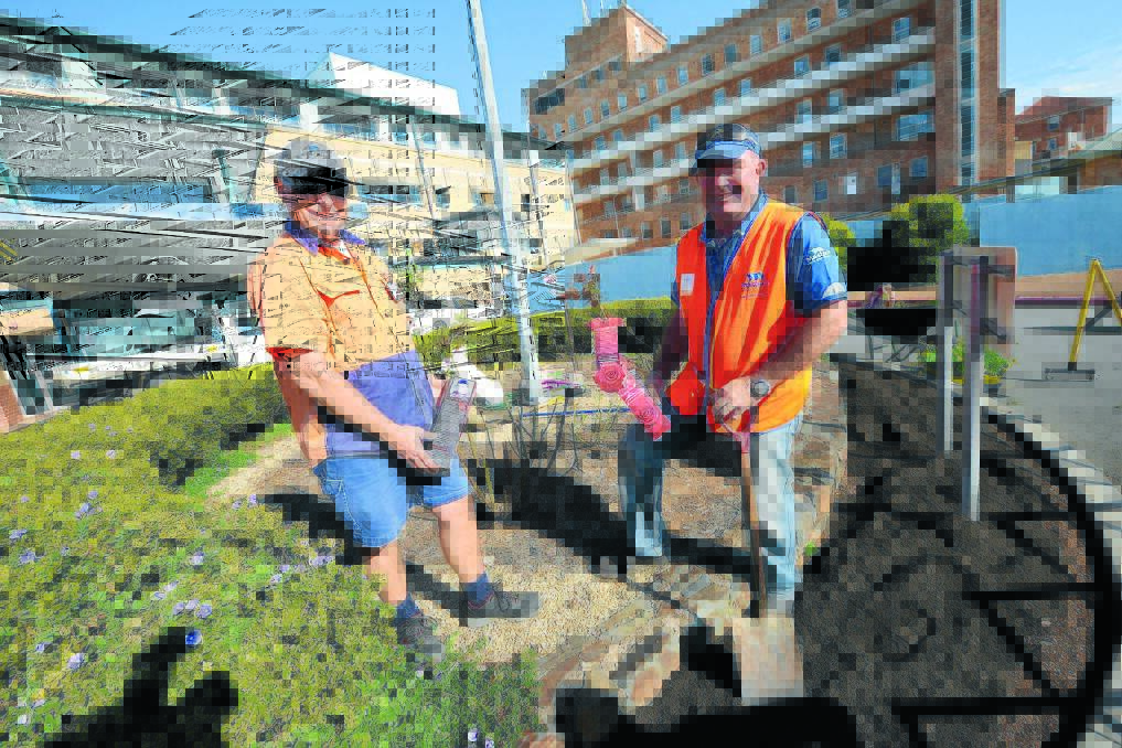 Manning Hospital's Andrew Somerville and Craig Greenaway from Masters planting a Daniel Morcombe Rose in the hospital's garden.