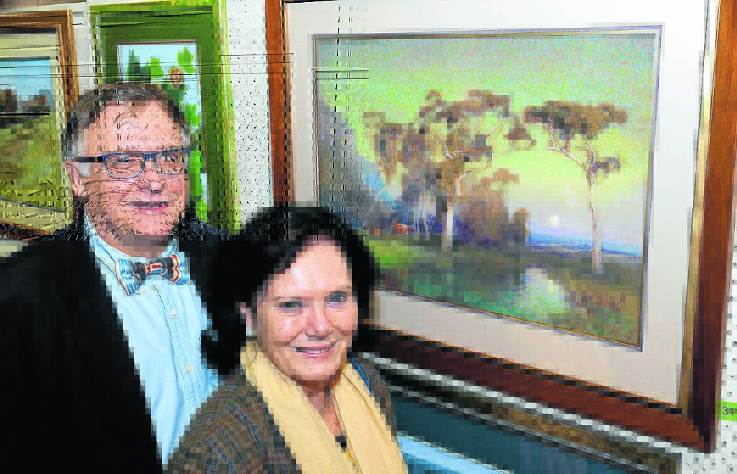 Dr Philip and Dusty Walkom with the winning best in exhibition artwork, Hunter Valley Moonrise, by Graham Cox.