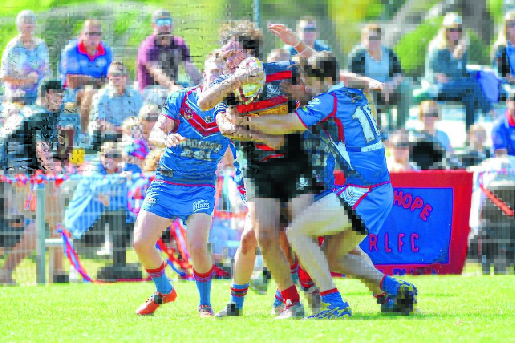 Old Bar's Isaac Worboys is wrapped up by Wauchope defenders during this year's Group Three under 18 grand final, won by Wauchope.