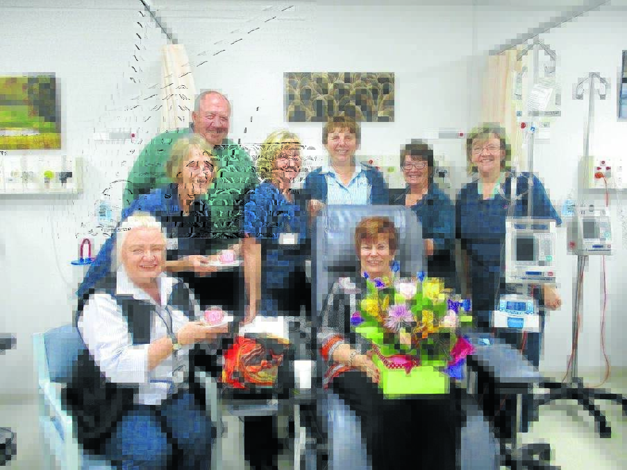 Wayne Blunt and his wife Sue (holding flowers) with Karen O'Donnell, Jenny McKeough, Maureen Hogan, Rachel Pitt, Kallee Niksic and Sue Wetton from the oncology unit, at Sue's 100th treatment.