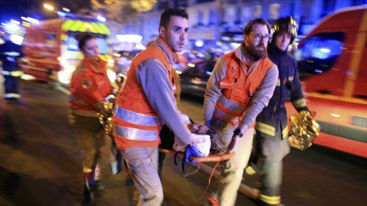 A woman is evacuated from the Bataclan theatre in Paris.  Photo: Thibault Camus