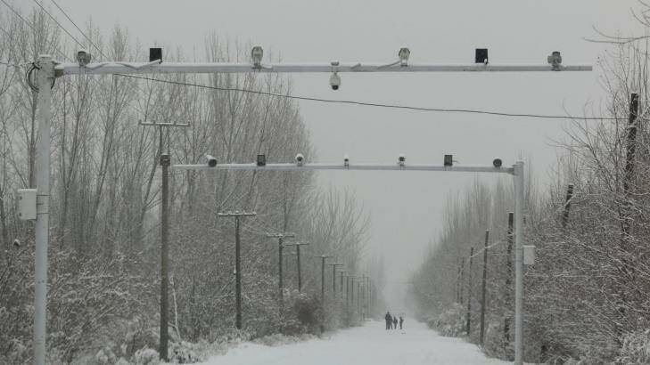Surveillance cameras keep watch on a road in Akto County, Xinjiang. Photo: Sanghee Liu
