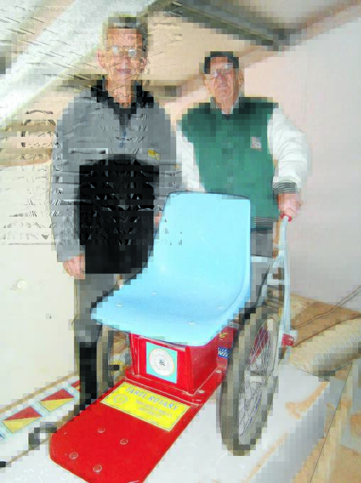Pictured: Len Keogh (left) and Mark Jensen (right) of the Taree Manning River Men's Shed with a completed wheelchair made from pushbikes.