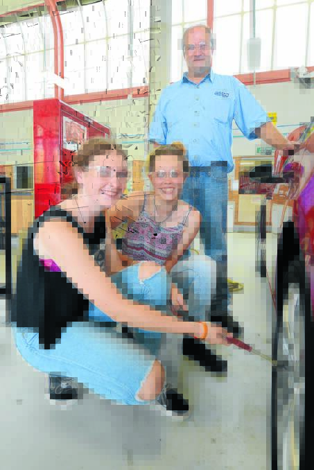Mackenzie Peacock and Maddi Drury learn to change a tyre with teacher Jason Hudson.