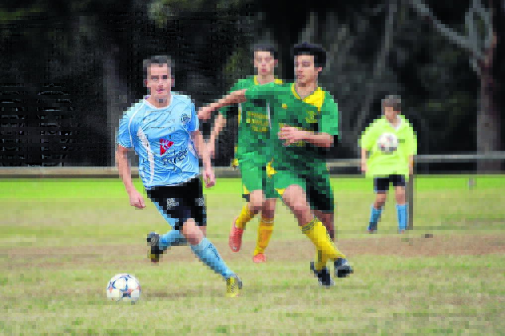 Alex Ihlow (right) from Wingham and Taree s Tom Griffen give chase to the ball during the premier league clash this month. Wingham faces Kempsey Saints tomorrow at Wingham in a game the Warriors must win. See more page 29