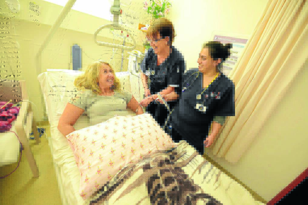 Easy does it: Patient Darelle Lovenfosse is made comfortable by nurses Tania Griffiths and Anna Styles using one of the new electric beds at Manning Hospital.