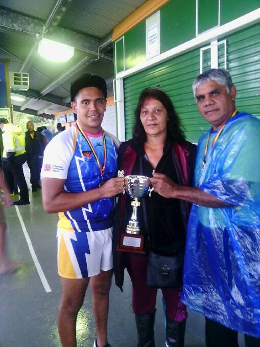 Anthony Jnr's brother Aden, mother Mirinda and father Anthony Snr with the men's trophy. 