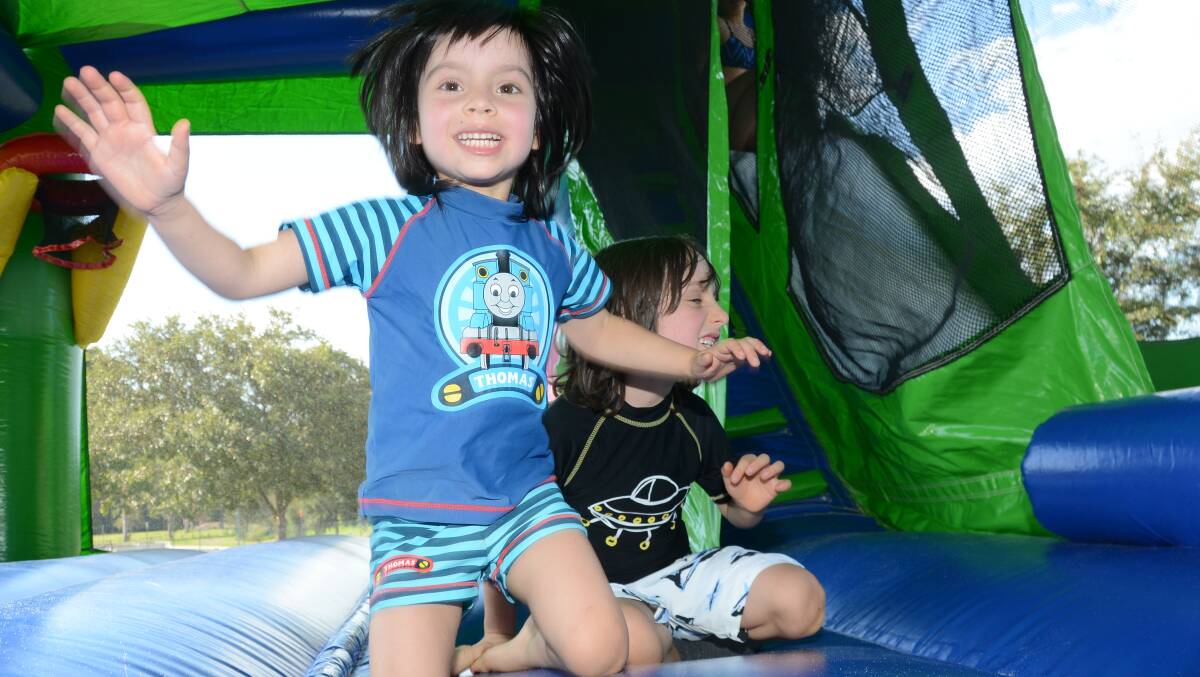 Kit and Jasper Hardy bounce happily on the jumping castle at the YMCA Kids Fun Day.