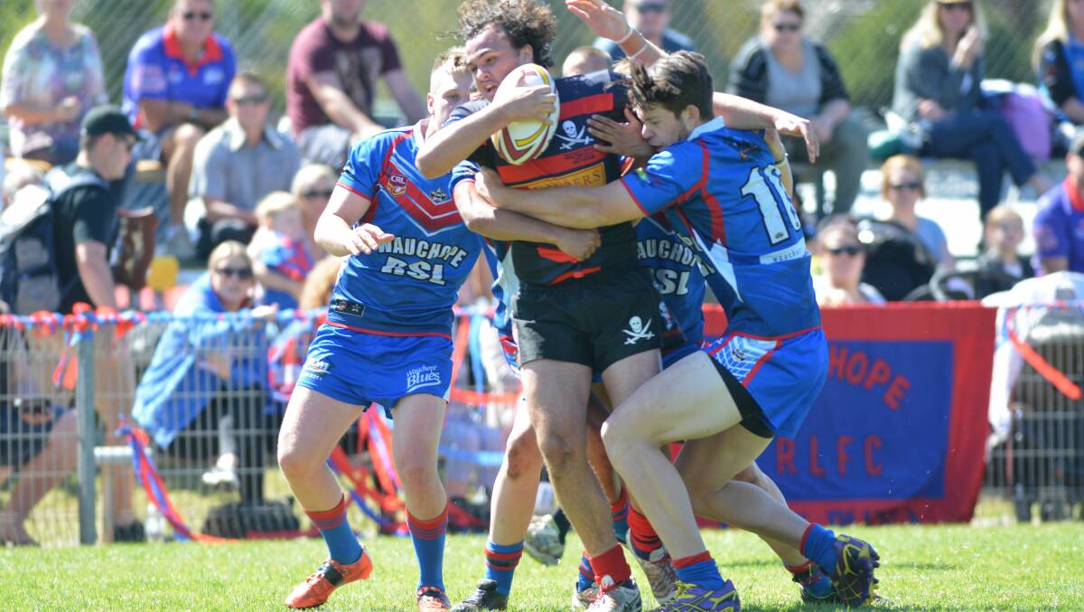 Old Bar five-eighth Issac Worboys is stopped by Wauchop defenders during the under 18 grand final at Port Macquarie.