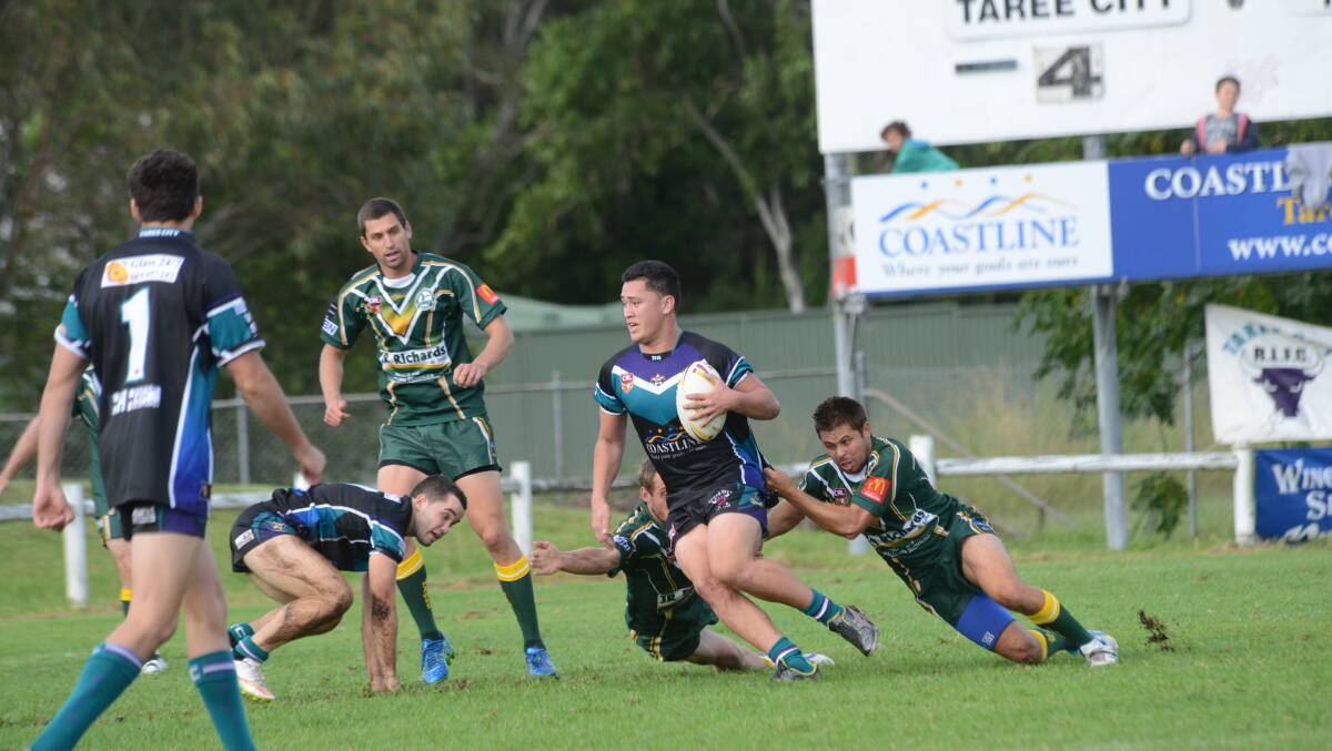 Taree City centre Aaron Bayley is grabbed by Forster-Tuncurry defenders during the Group Three Rugby League game at Taree. Forster won 40-22.