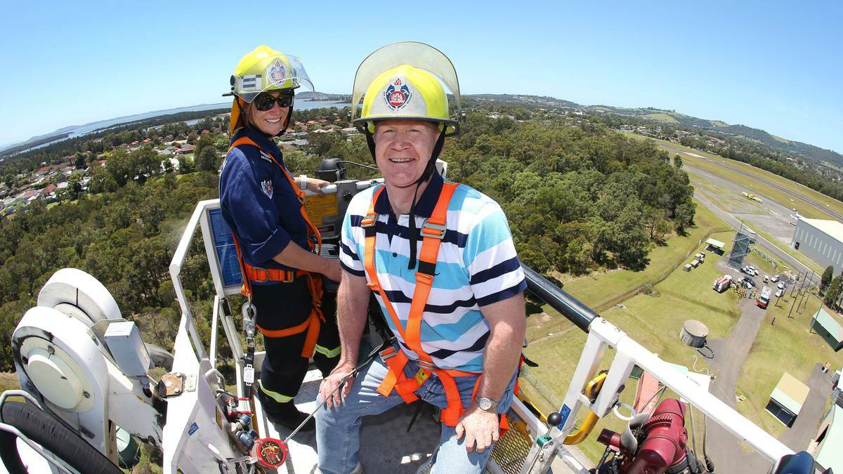 Sydney NSW Fire and Rescue IT employee Alan Thompson is lifted into the air with senior fire fighter Leticia Harris in an aerial ladder platform. Picture KIRK GILMOUR