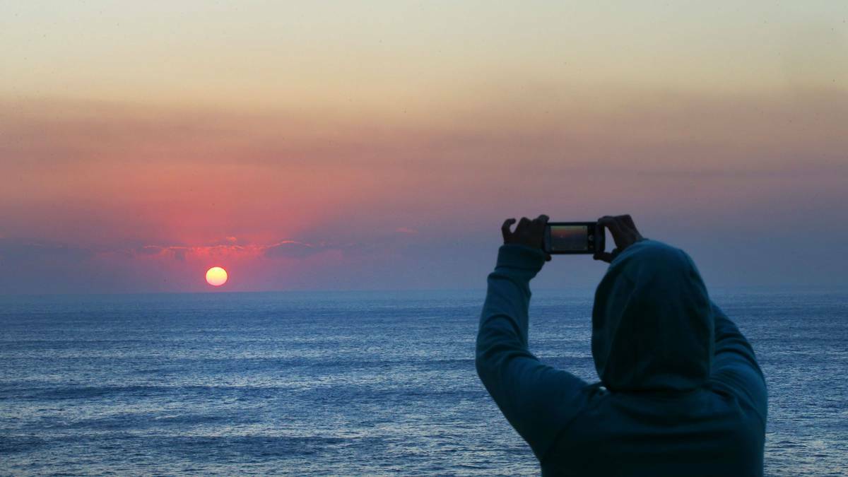 A local at Austinmer takes a photo of the bushfire haze hanging over the Illawarra on October 19. Picture KIRK GILMOUR