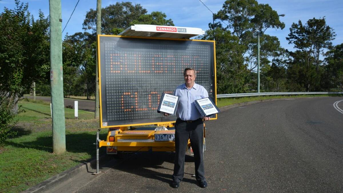 April 10: Greater Taree City councillor Peter Epov holding the petition folders with 17,496 signatures for the "Better Roads and Safer Bridges" campaign.