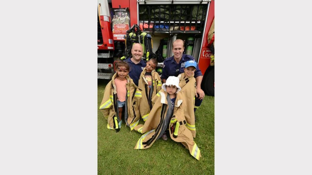 Fabulous firemen Scott Bussey and Daniel Marriott help Eric and Myesha Dumas and Ezekiel and Kyeema Saunders try-on uniforms at the Mid North Coast Family Referral Service Family Fun Day in Taree.