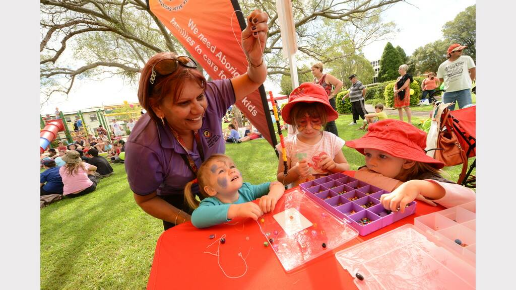 Chloe and Zara Cameron, Kelsey James and Sharon Cochrane work carefully to create a beautiful beaded necklace at the Mid North Coast Family Referral Service Family Fun Day in Taree.