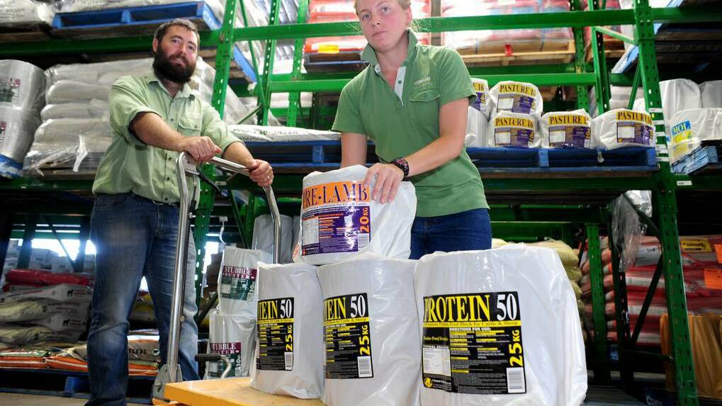 DAILY LIBERAL (Dubbo) - Landmark agronomist Ash Freeth stocking dry feed blocks with merchandise manager Damien Larnach. The blocks will be in hot demand if good rain doesn't fall soon. Photo: LOUISE DONGES