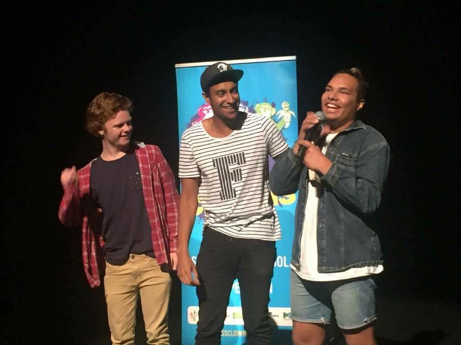 Gregg Andrews holds the mic at the Melbourne
International Comedy Festival's Class Clowns
State finals in Sydney. Next to Gregg is Triple J
breakfast presenter Matt Okine and Will Gibb
from The Scots College, who also made it to nationals
in Melbourne. 