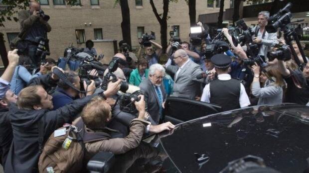 Centre of the storm: Rolf Harris leaves the court as a guilty man. Photo: Reuters