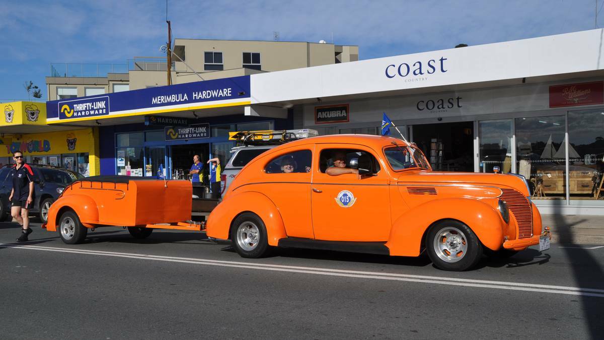 Loud and proud … car and trailer add a real splash of colour as it makes its way up Market Street Merimbula. The car was one of 210 cars in the Royal Automobile Club of Victoria’s (RACV) Fly the Flag eight day tour that chose to spend two nights in Merimbula.
