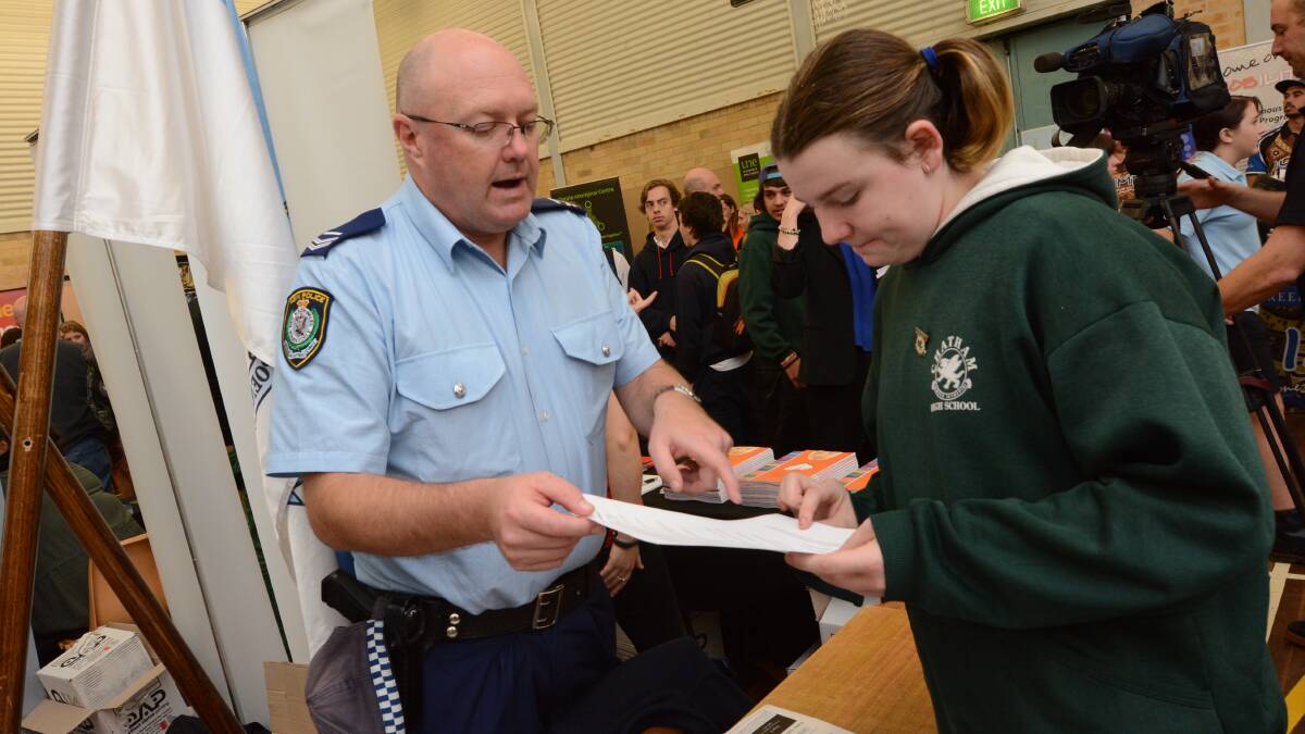 Senior Constable Ray Slade explains careers in the force to an interested Trinity Miller of Chatham High.
