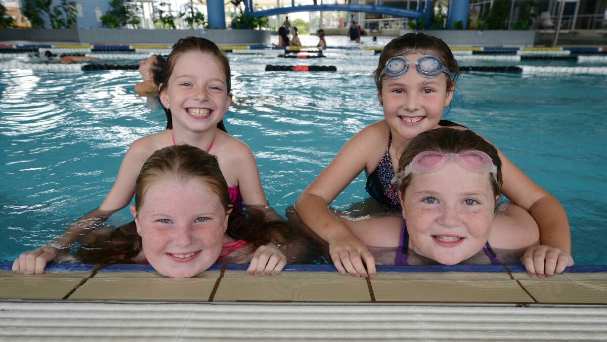Happy faces at the pool edge. Tina McCarthy, Ainjel Heaslip, Tahlia Miller and Emma Fawcett enjoy playing in the pool at the YMCA Manning Aquatic Leisure Centre.