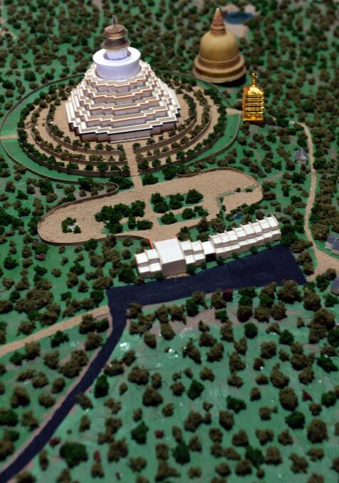A model of the future site. The two gold buildings near the Great Stupa are stupas of other Buddhist traditions. The small, white buildings are houses. 