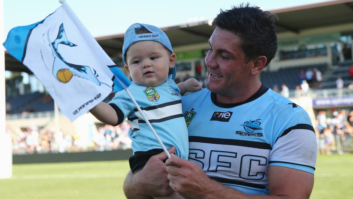Chris Heighington of the Sharks walks with his son Rocco on field after the match. The Sharks trounced the Warriors 37-6 to record their first win for the season. Picture: Getty Images