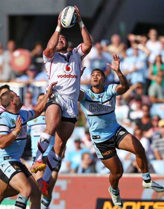 Konrad Hurrell of the Warriors reaches the high ball ahead of Ricky Leutele. The Sharks trounced the Warriors 37-6 to record their first win for the season. Picture: Getty Images