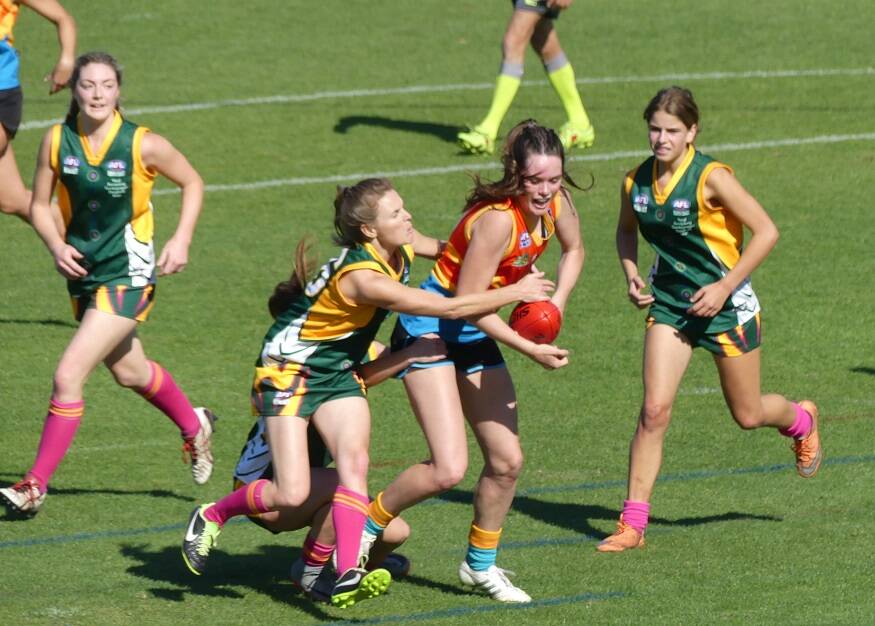 Port Macquarie's Cambridge McCormick looks to clear the ball in a match between Mid North Coast and North Coast. 