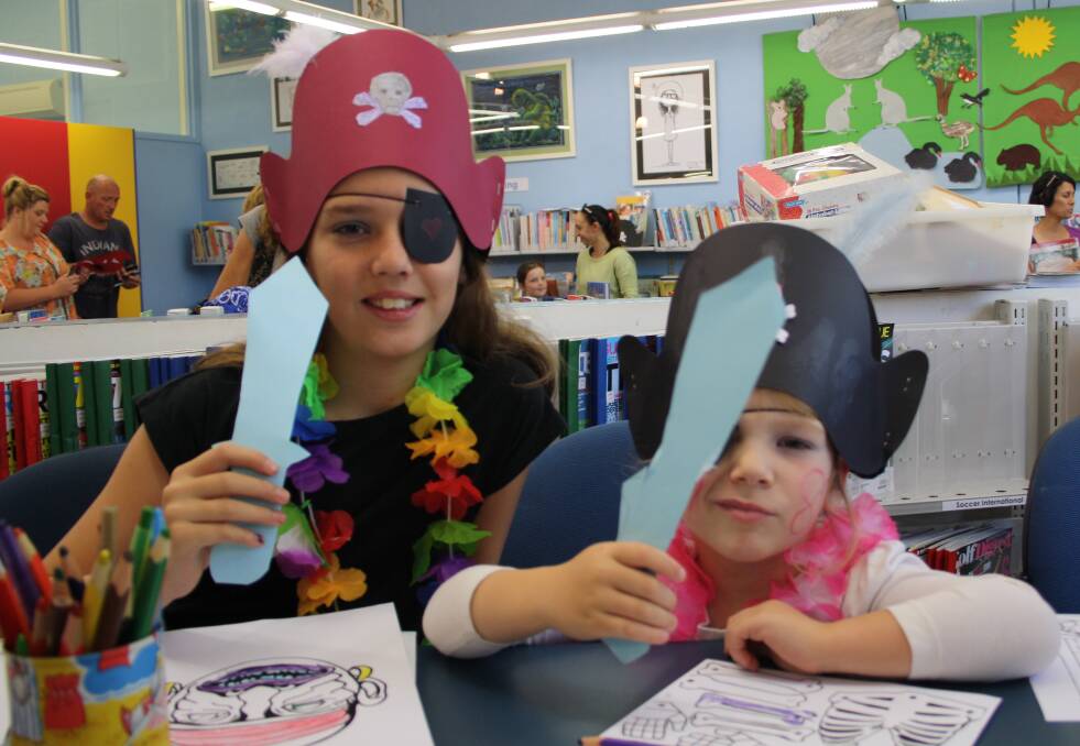 Jasmyne Ussia and Tileah Hooklyn dress up as pirates in the library.