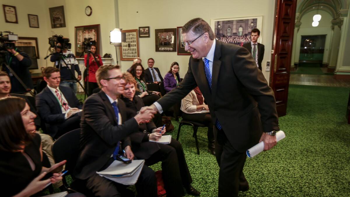 Former premier Denis Napthine shakes hands with reporters prior to his resignation speech at State Parliament on Monday morning.
