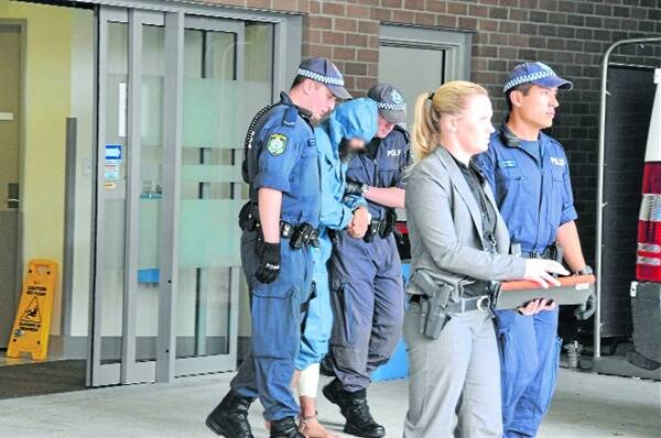 Fugitive Malcolm Naden under police escort yesterday after treatment at Manning Hospital.