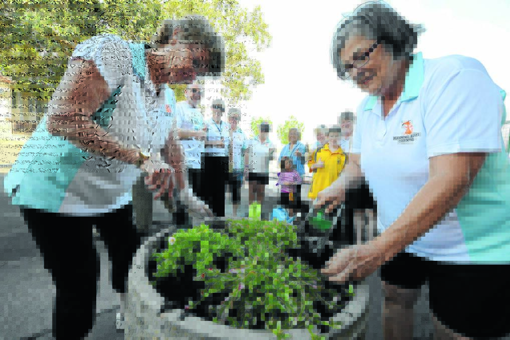 Judy Poole and Margaret Kurtz plant up pots in Pulteney Street. Their skill at planting is given the thumbs-up by (from left) Tidy Up Taree organiser, Graham Brown, Debbie Ashwell, Jan Sage, Cathy Stenchion, Jenifer Schubert, Marylyn Ayoub, Amali Shultz, Sue Cross, Sue Calvin, Jade Page and Sean Page.
