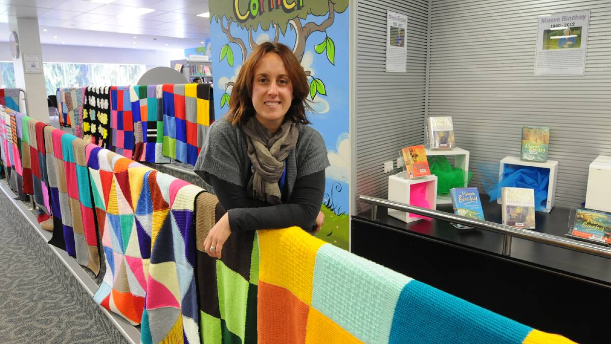 Greater Taree Libraries’ events coordinator, Danielle Old with some of the wraps created during this year’s knit-in. Below left, Carly Gander snug among the knitted squares and below right, knitter Kate Hayward.