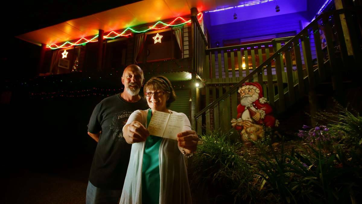  NEWCASTLE: Glenn and Jo Currington of 47 Kenley Crescent, Macquarie Hills, with their card with a score of B from the Friendly Neighbourhood Christmas Lights Critic. Pictures: Peter Stoop